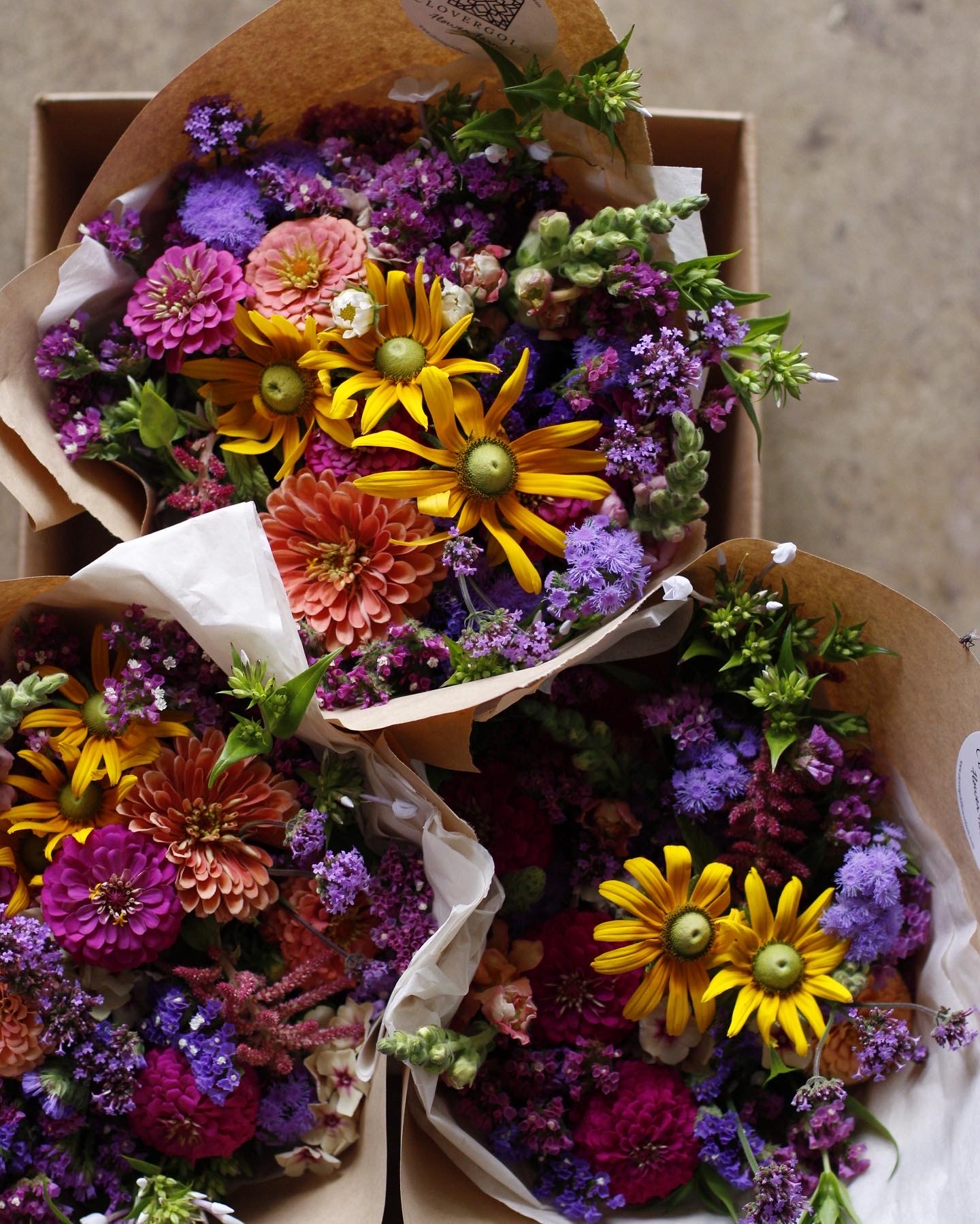 A colorful bouquet of flowers featuring yellow, shades of pink, and shades of blue and purple.