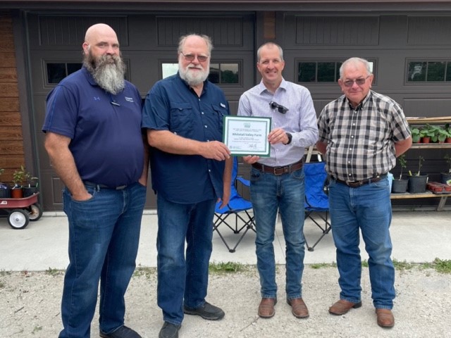 4 men pose with a value-added certificate.