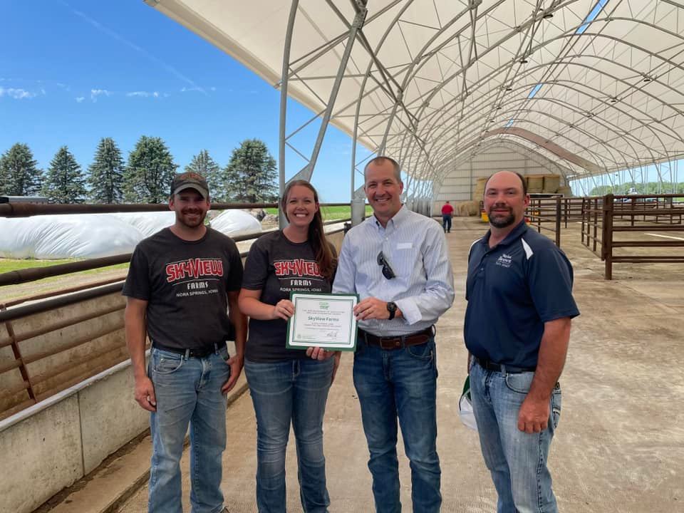 4 folks stand in a bar with a certificate