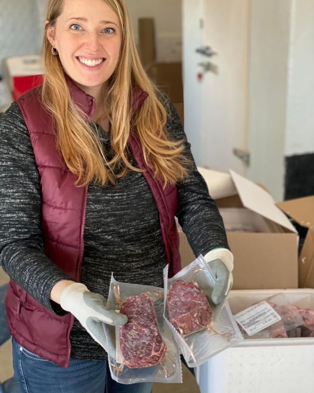 Tina Troester holds up some shrink wrapped packages of tenderloin.