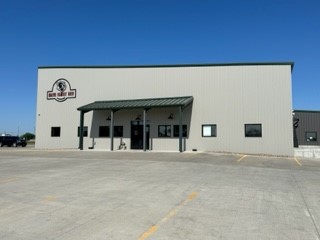 A grey metal building is the home of Meat & Greet