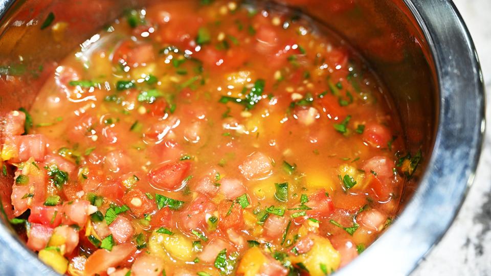 A bowl of salsa fresca with bright red tomatoes and yellow peppers.