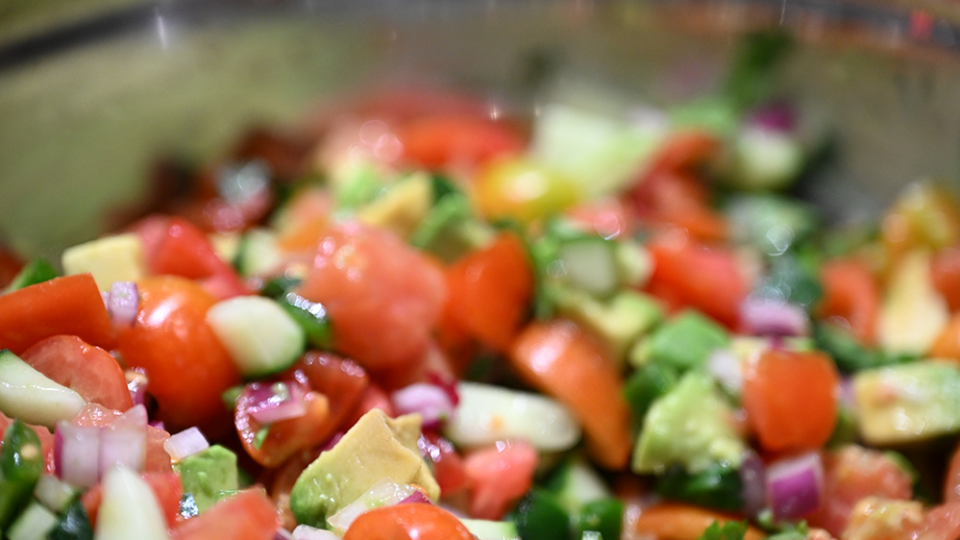 A dishes of brightly colored vegetables is ready for eating.