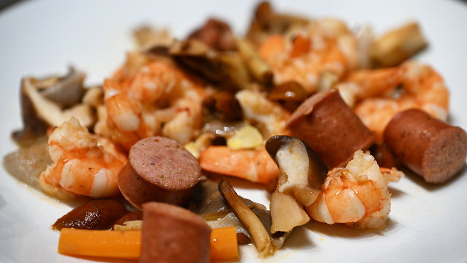 Pieces from the shrimp boil including shrimp, sausage, potatoes and more are ready for eating.