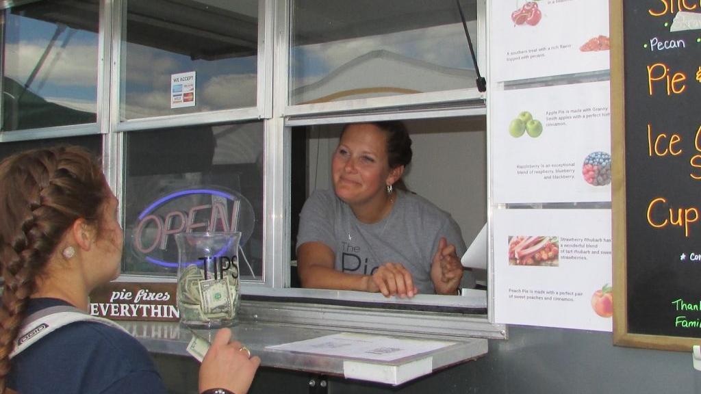 Owner/ Operater Laura Bru serving a customer out of the mobile food trailer 