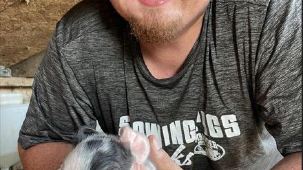 Aaron holding piglet. 