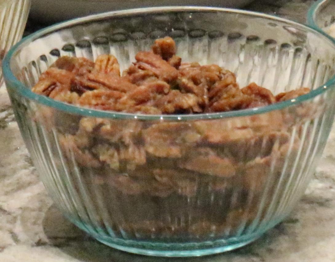 A bowl of candied pecans sits ready for a salad.