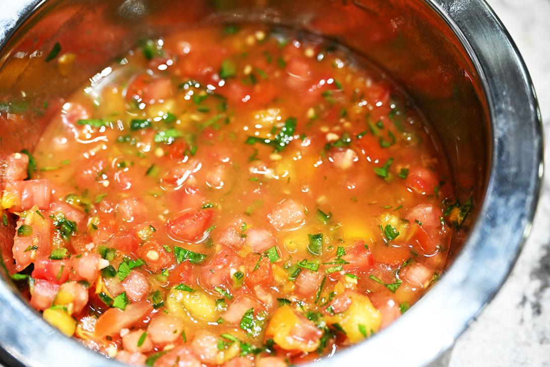 A bowl of salsa fresca with bright red tomatoes and yellow peppers.